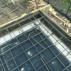 Gotowe zbrojenie ławy fundamentowej, przygotowane do zalania betonem. Stalowe pręty tworzą solidną siatkę.