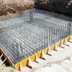 Siatka zbrojeniowa gotowa do zalania betonem, tworząca solidne zbrojenie ściany fundamentowej.