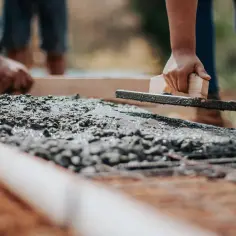 Ludzie pracują przy wylewaniu betonu. Zastanawiasz się, ile waży kubik betonu ile to kg?