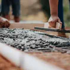 Ręczne wygładzanie świeżego betonu. Cement to tylko jeden ze składników, beton to mieszanka cementu, kruszywa i wody.
