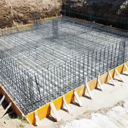 Siatka zbrojeniowa gotowa do zalania betonem, tworząca solidne zbrojenie ściany fundamentowej.