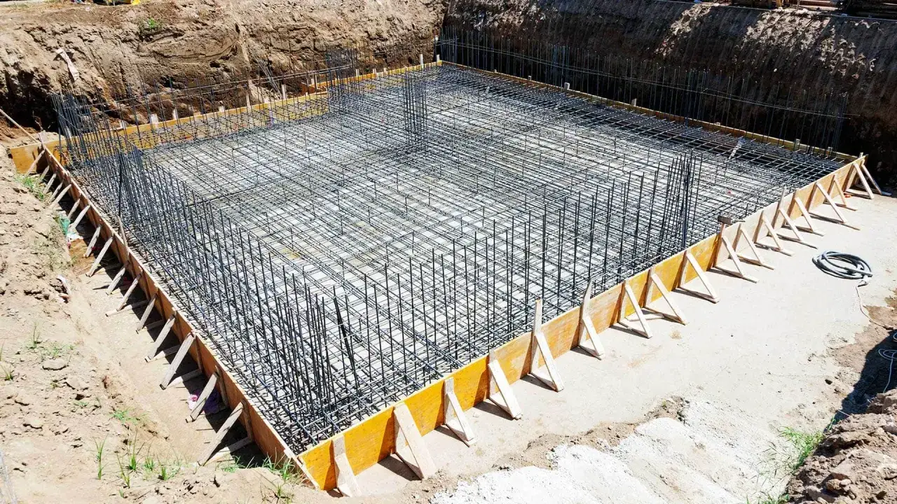 Siatka zbrojeniowa gotowa do zalania betonem, tworząca solidne zbrojenie ściany fundamentowej.