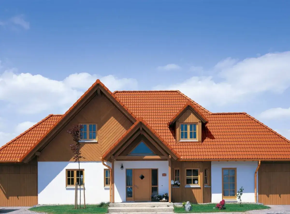 Dom z pomarańczowym dachem, gdzie dachówka betonowa czy ceramiczna tworzy ciepłą, przytulną atmosferę.